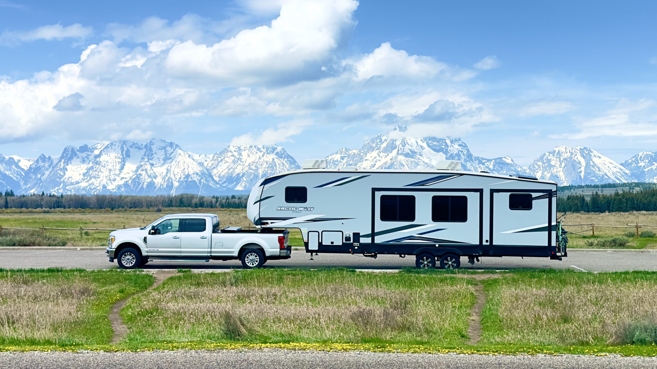 Truck towing fifth-wheel RV through the mountains