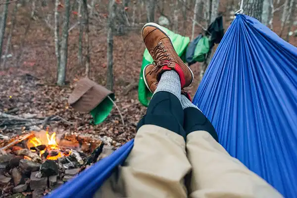 Person laying in hammock while camping in forest