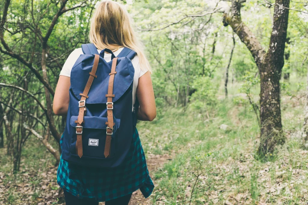 Woman hiking through forest with backpack