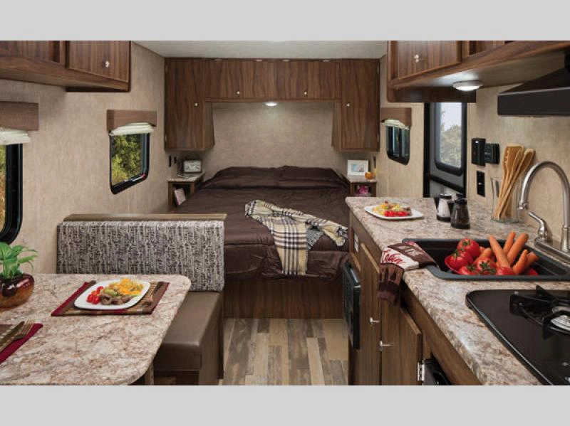 Viking Saga travel trailer interior showing bed, dinette, and kitchen areas
