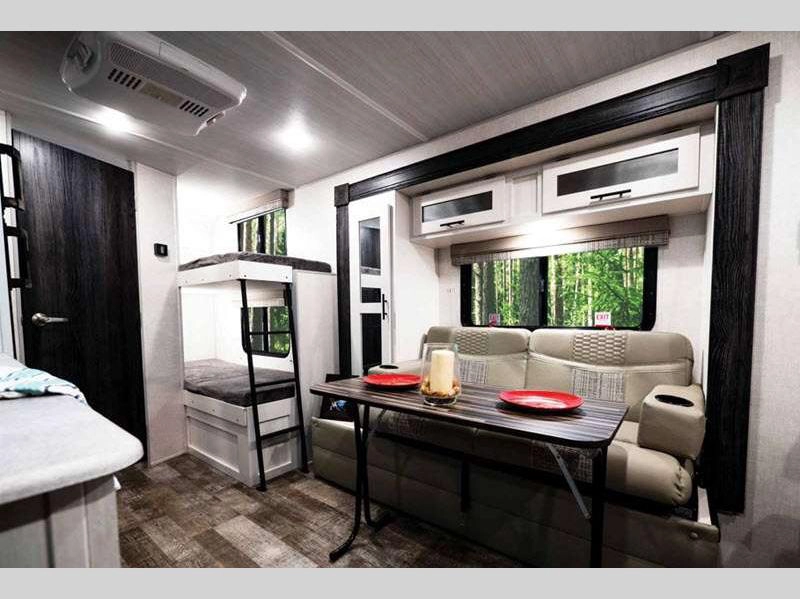 R-Pod Travel Trailer interior showing seating area, table, and bunks