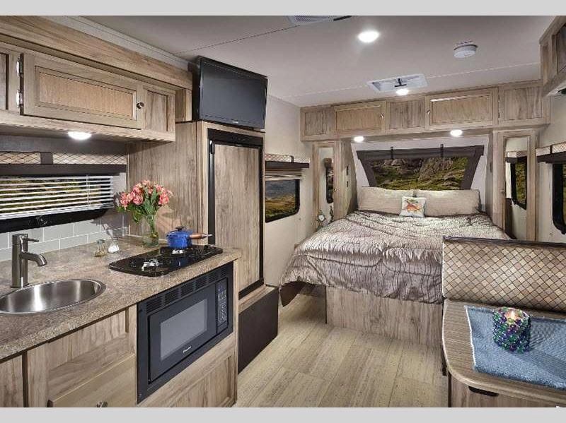 PaloMini travel trailer RV interior showing bed, dinette, and kitchen area