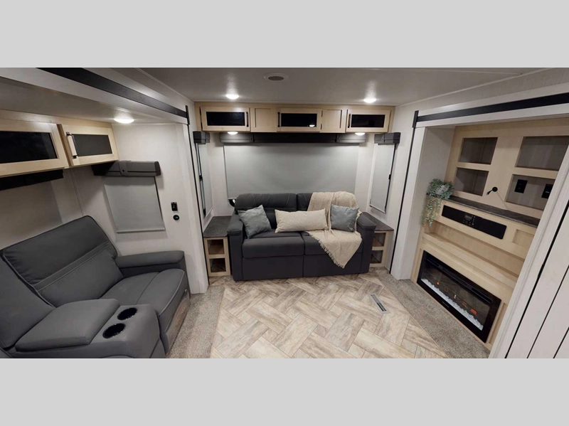 Puma Travel Trailer- living room with sofa, recliners, fireplace, and storage cabinets