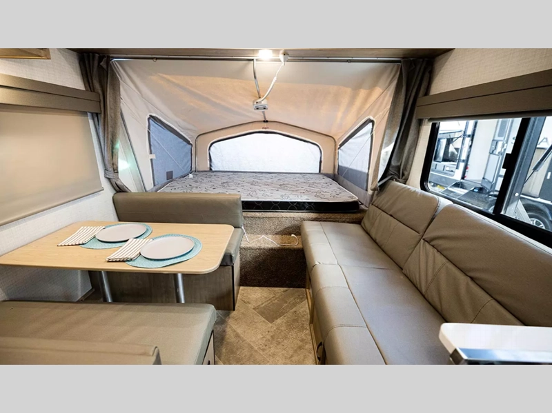 Interior floorplan of a Solaire expandable RV showing bed, dinette, couch, LED lighting, and windows with roller shades