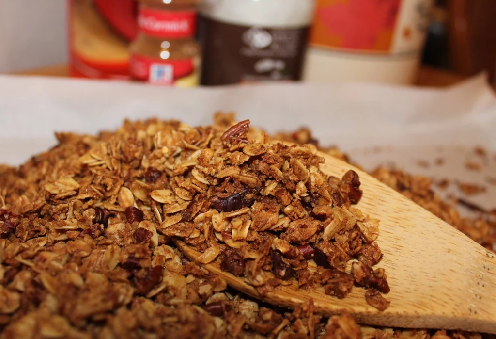 Stirring homemade granola trail mix with wooden spoon