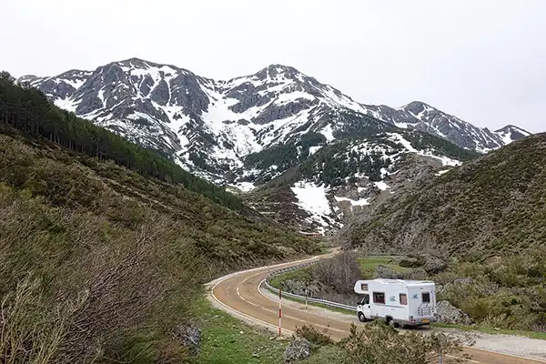 Motorhome RV driving through a scenic road with mountains