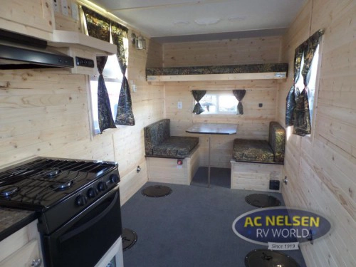Ice house camper interior with bunk, dinette, and fishing holes